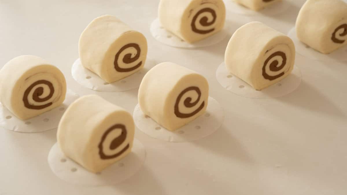 Close-up of creamy Swiss rolls neatly arranged on a light surface, perfect for dessert inspirations.
