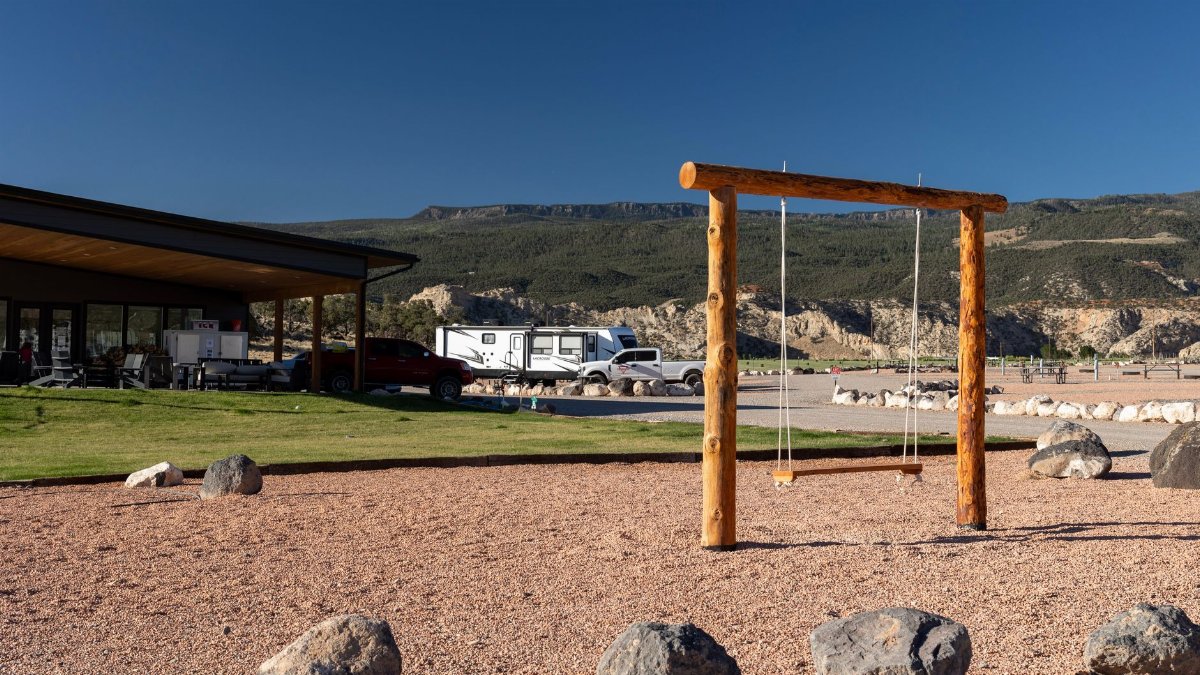 Peaceful playground scene with swings and stunning mountain backdrop in Teasdale, Utah.