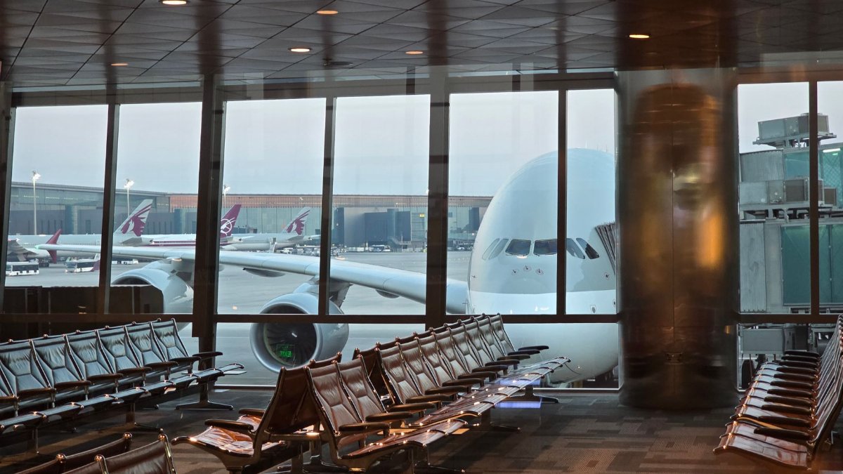 A passenger plane at Hamad International Airport in Doha with empty seating area in the foreground.