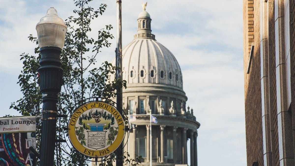 Iconic dome of Boundary County Courthouse set against clear sky, with street sign in foreground.