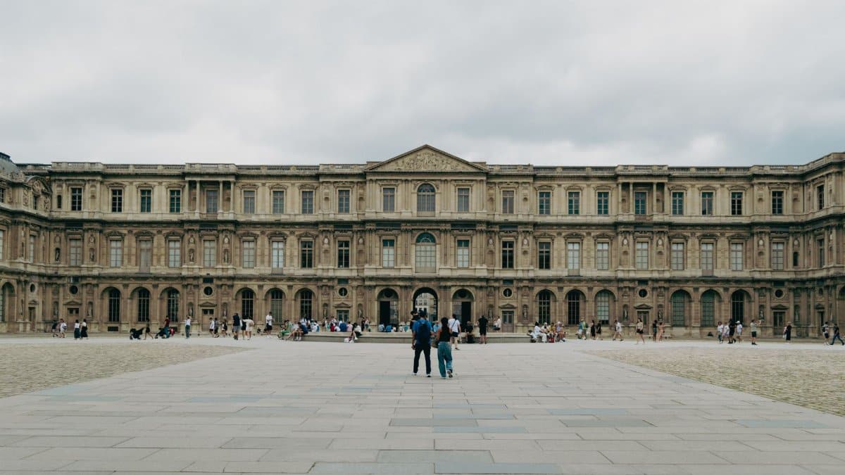Wide view of the historic Louvre Museum in Paris, showcasing classic architecture and cultural significance.