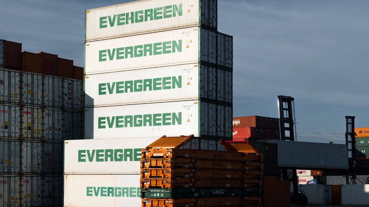 A stack of Evergreen cargo containers at Hamburg port, showcasing industrial logistics.