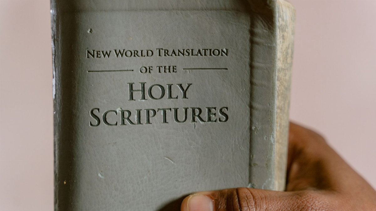 Close-up of a hand holding the New World Translation of the Holy Scriptures.
