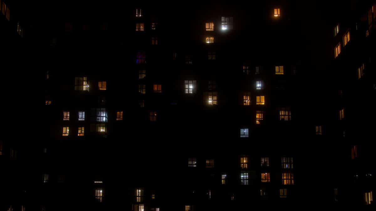 A cityscape view of brightly lit apartment windows against a dark night sky in Lviv, Ukraine.