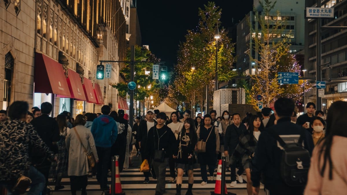 A crowded street in Osaka, Japan, bustling with diverse crowds on a winter evening.