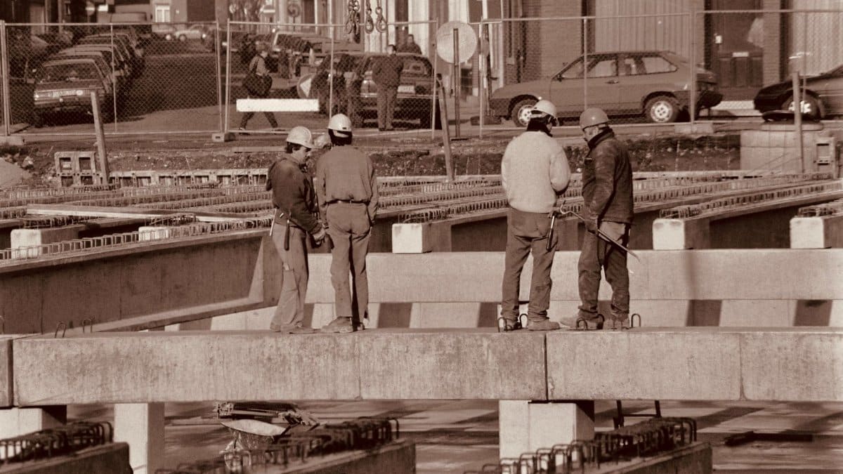 Group of construction workers discussing plans on an urban construction site.
