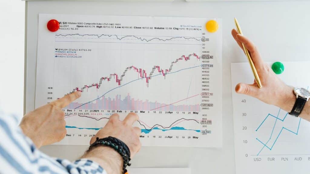 Two professionals analyze stock market graphs with a focus on finance and data trends.