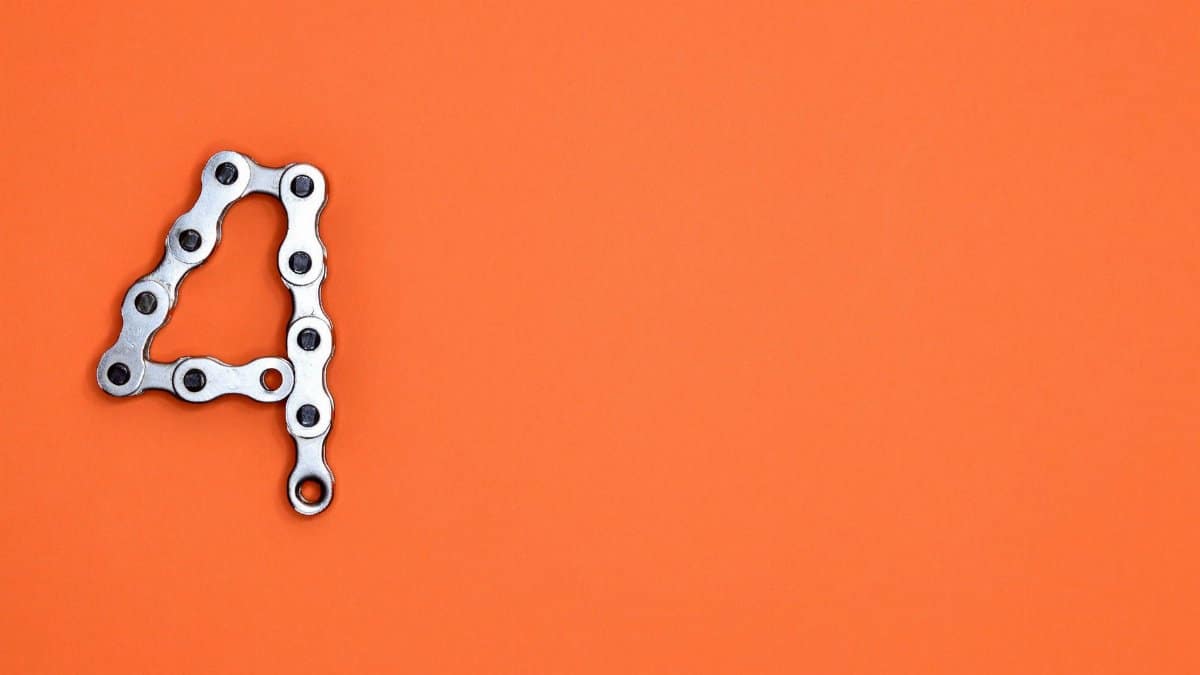 A creative design of the number four formed with a metal chain against an orange background, offering ample copy space.